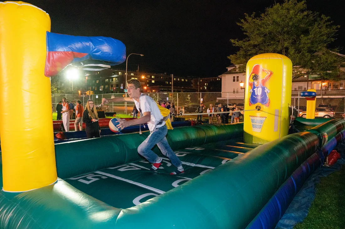 Student runs on inflatable football field bounce house