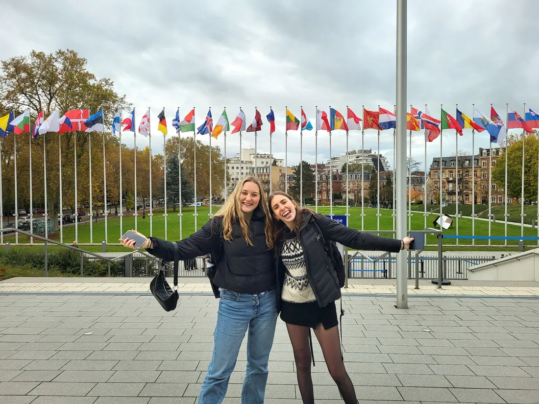 Two people smiling outside the world forum on democracy.