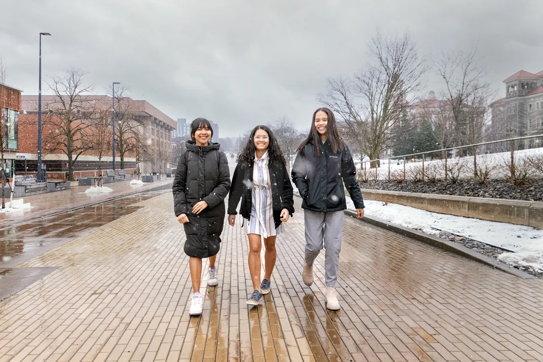 Three students walk outside together.