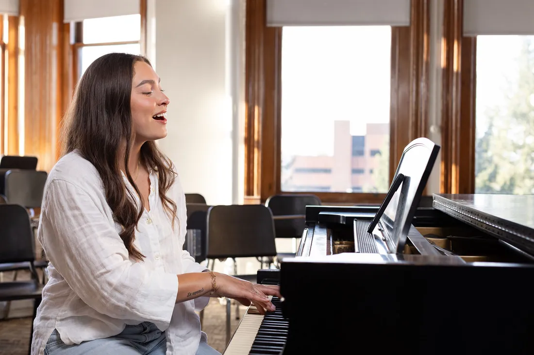 Olivia Pess singing at a piano.