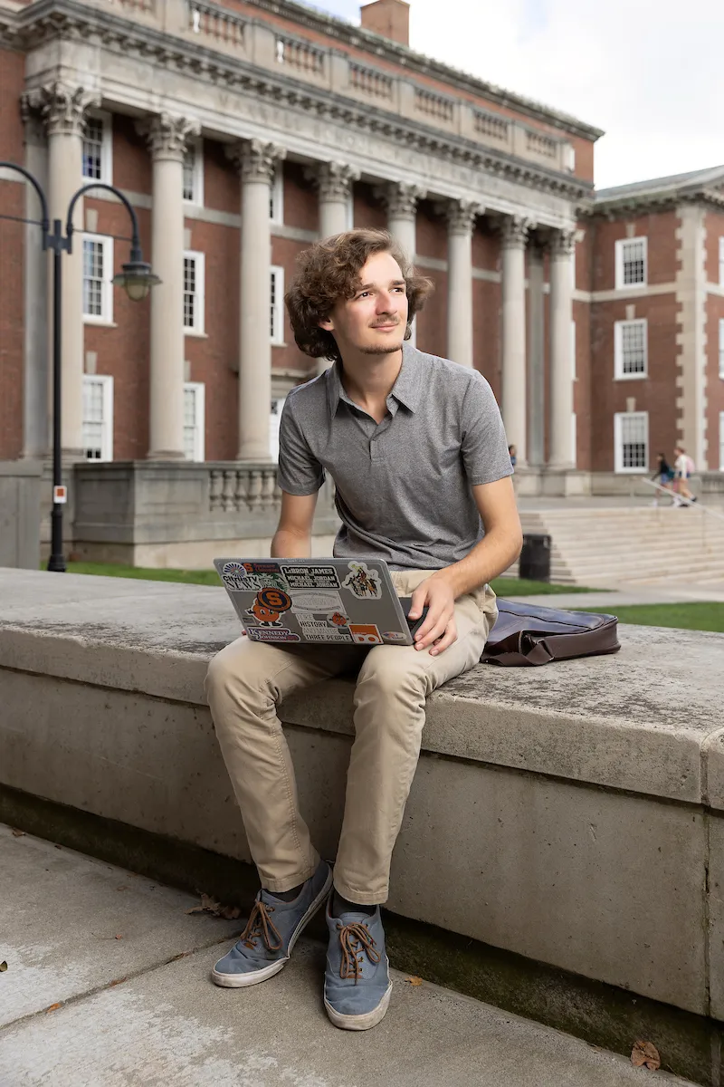Dominic Chiappone working on computer outside of the Maxwell School of Citizenship and Public Affairs.
