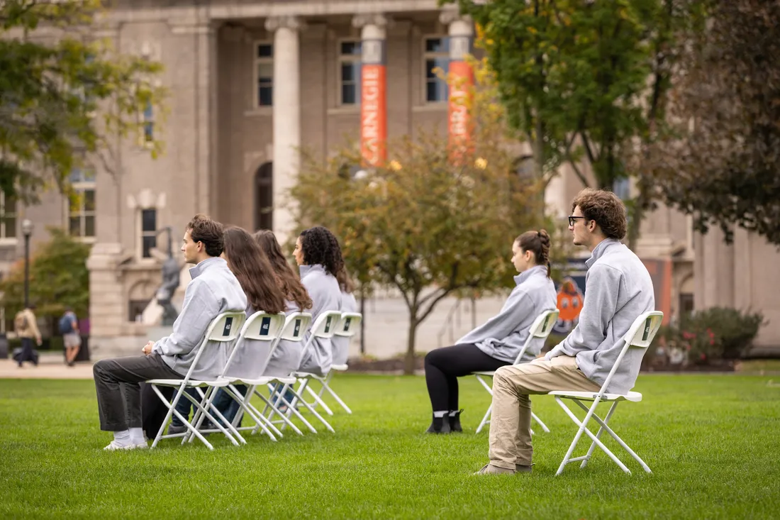 People sitting in chairs on campus.
