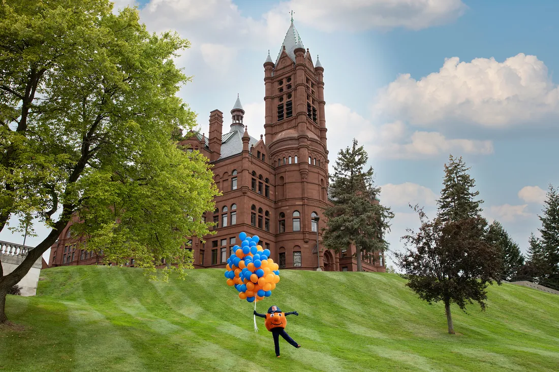 Otto in front of Crouse Hall holding balloons.