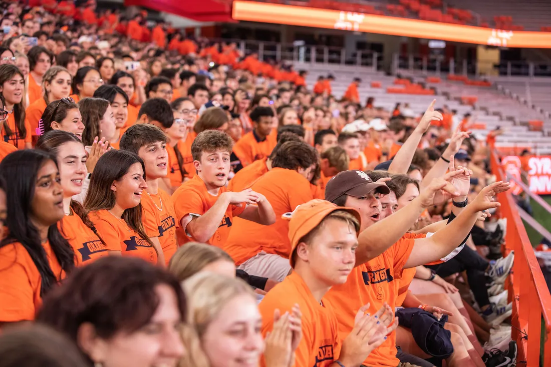 Students cheering together in the Dome wearing orange.