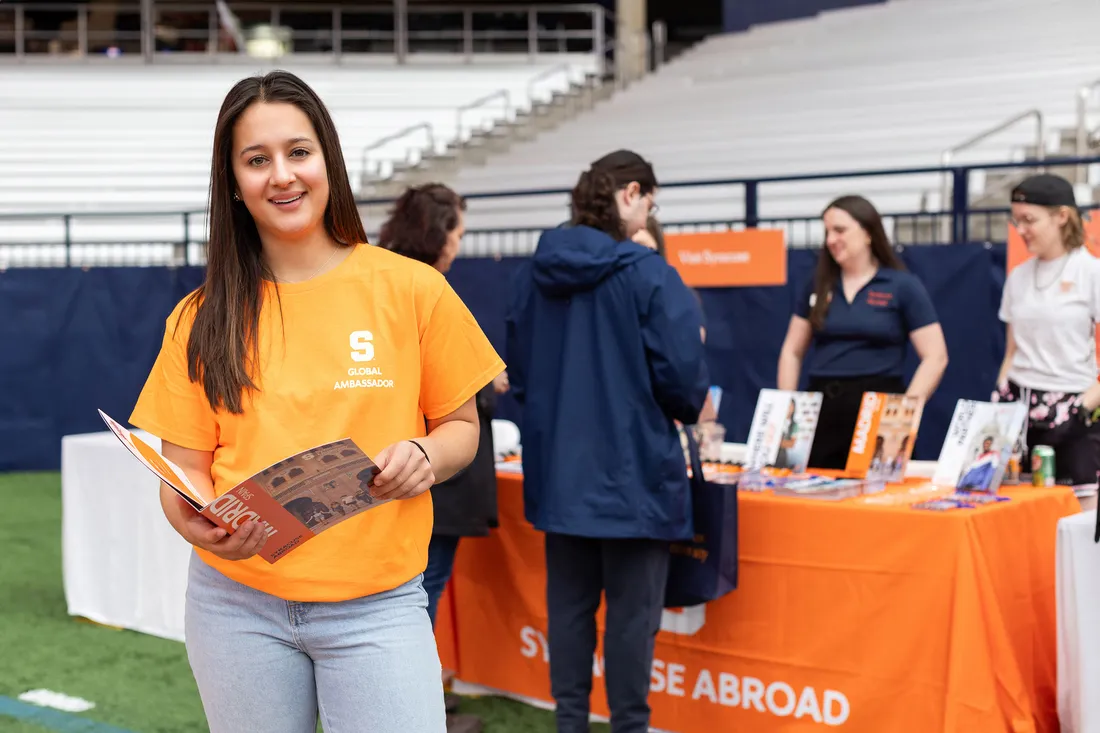 Talia St. Angelo in front of the Syracuse University Study Abroad table.