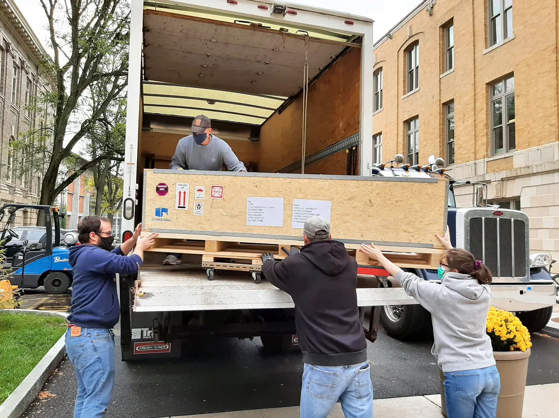 Members of the physics department load parts of the Upstream Tracker onto a delivery truck at Syracuse University.