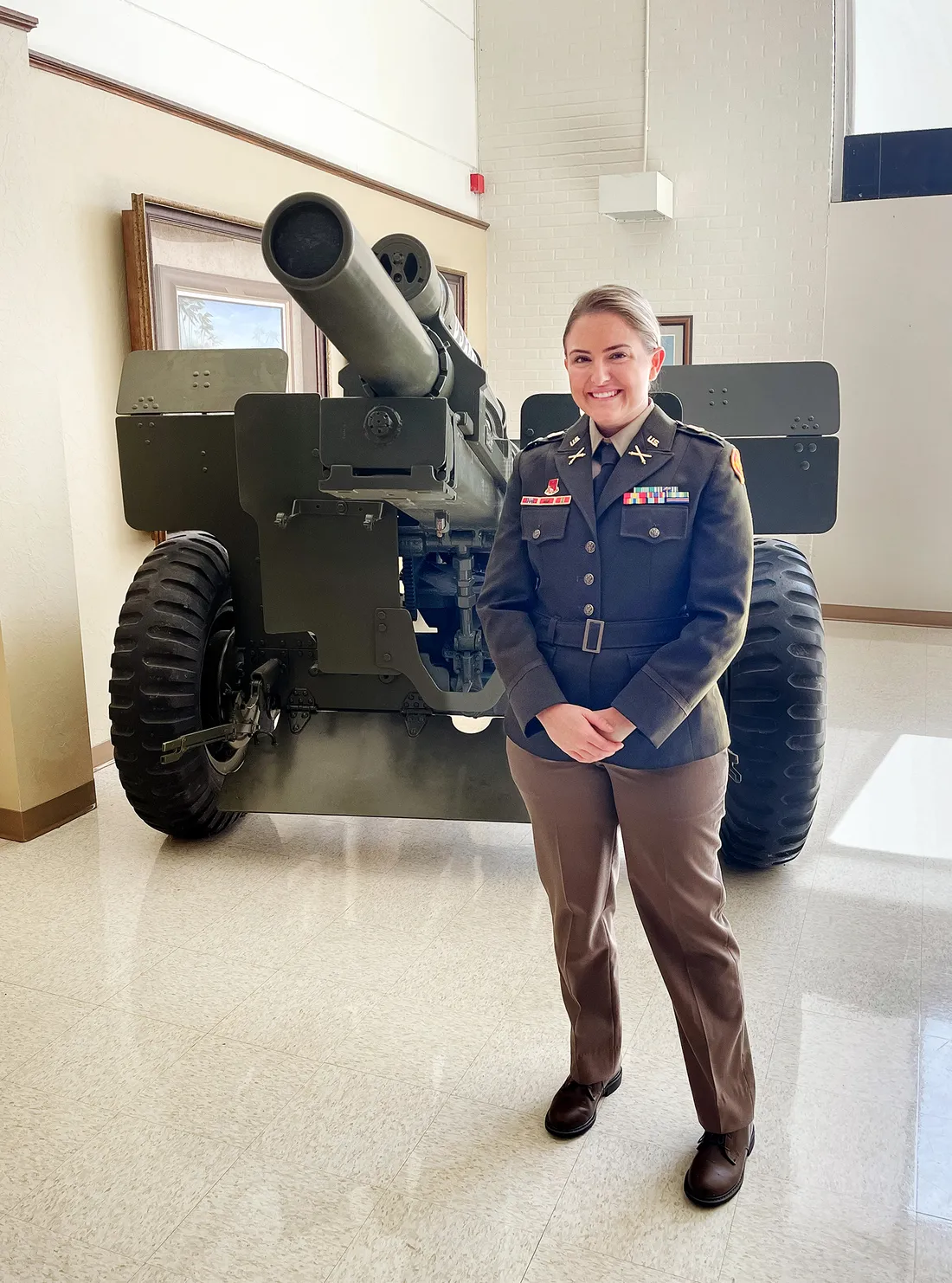 Portrait of Amanda Rylee standing beside a tank on display indoors.