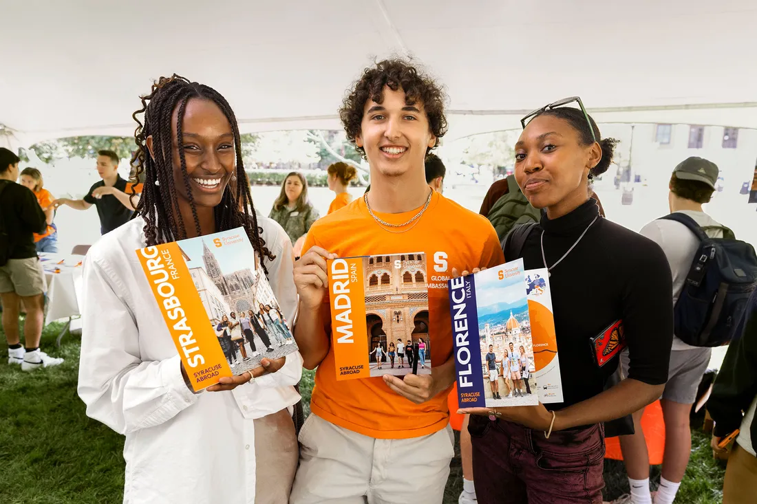 Students hold study abroad brochures