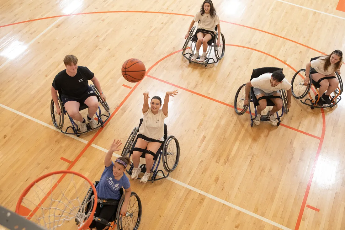 Students playing wheelchair basketball.