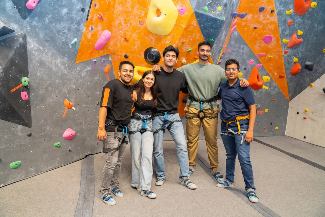 People standing in front of a rock wall.