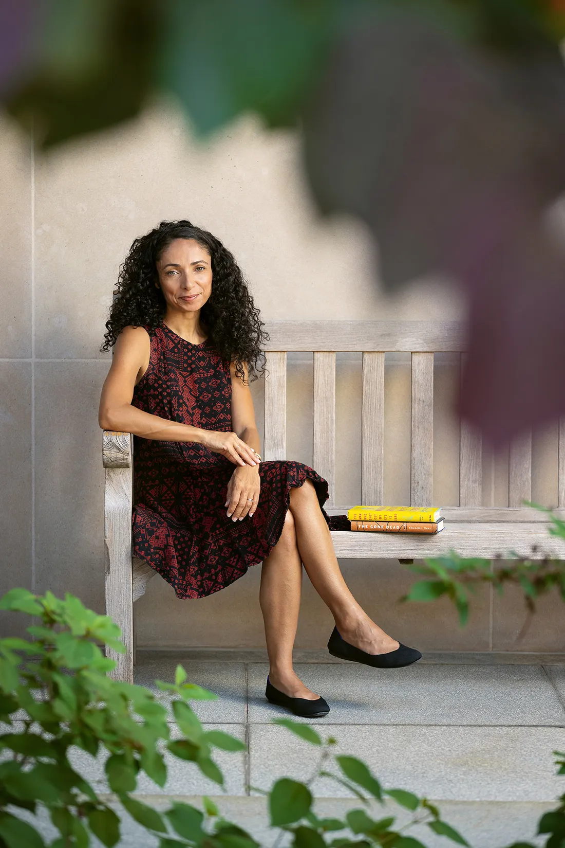 Portrait of Chanelle Benz sitting on a bench with her books, smiling.