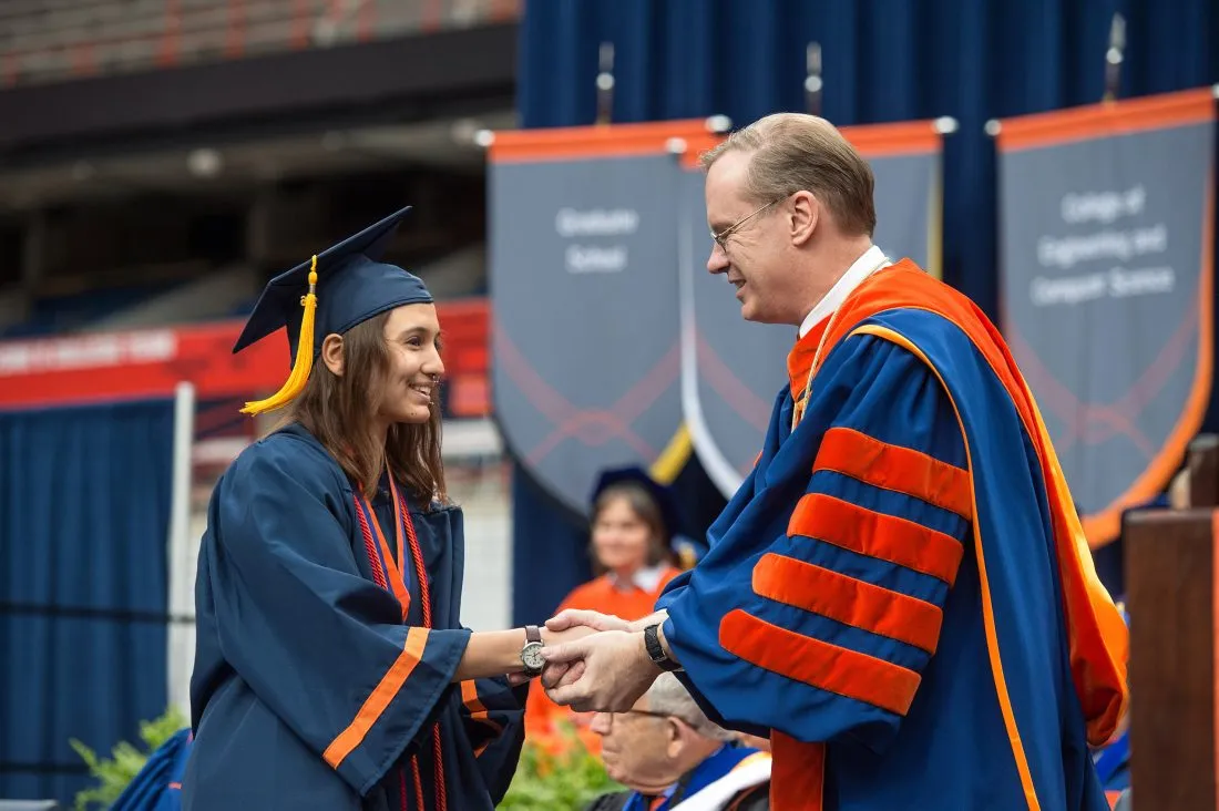 Samantha Usman shakes hands with Chancellor Kent Syverud at graduation.