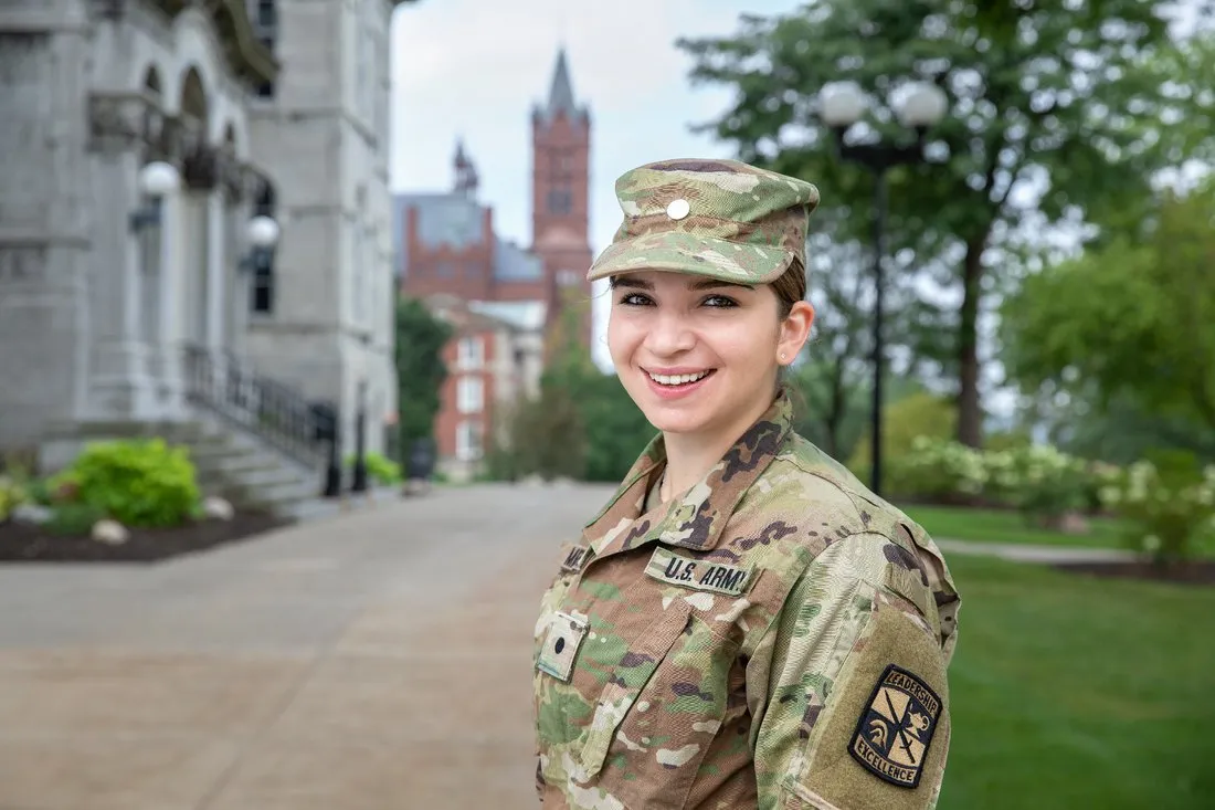 Military-connected student standing and smiling in uniform.