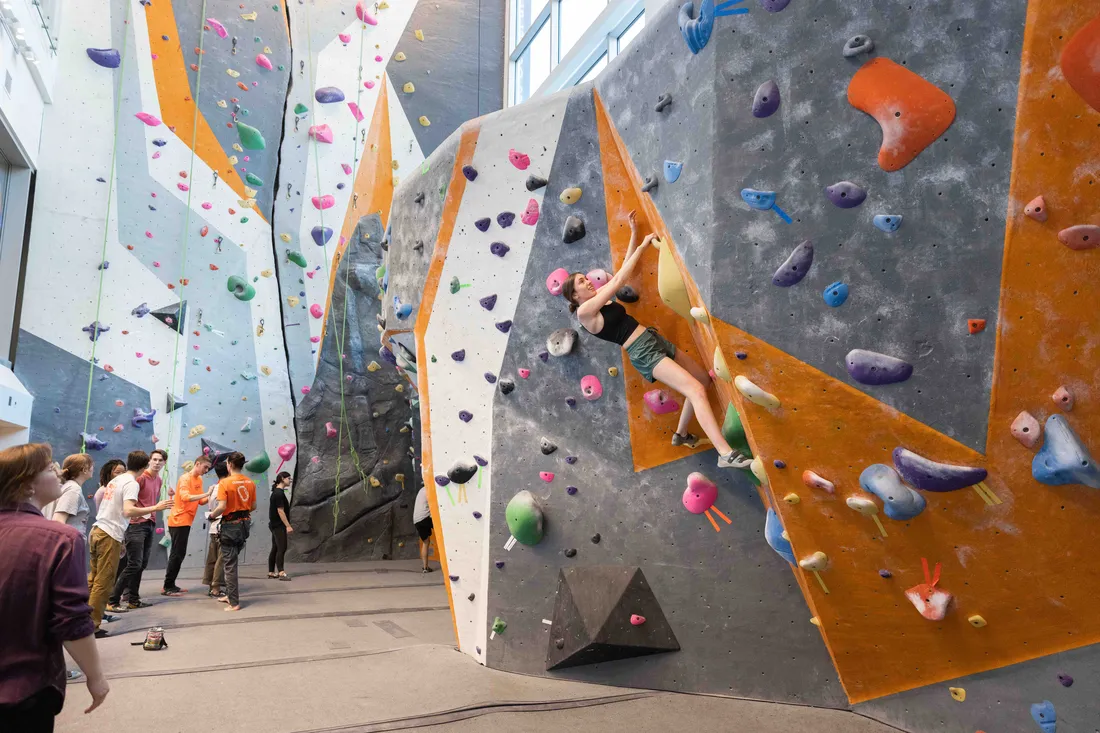 Students enjoy the indoor rock-climbing wall at the Barnes Center.