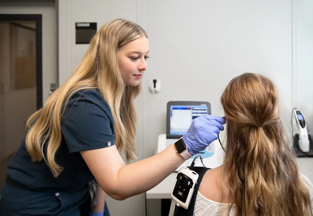 Student checking patients ears at the Gebbie Clinic.