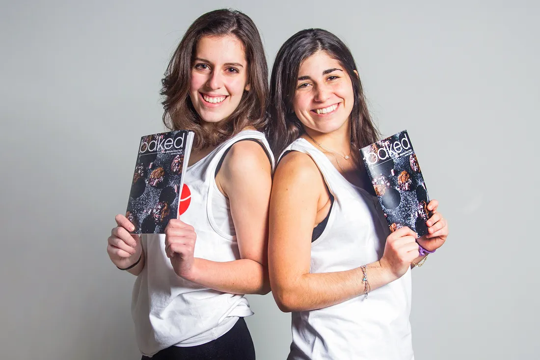 Two Baked Magazine employees, posing with magazines.