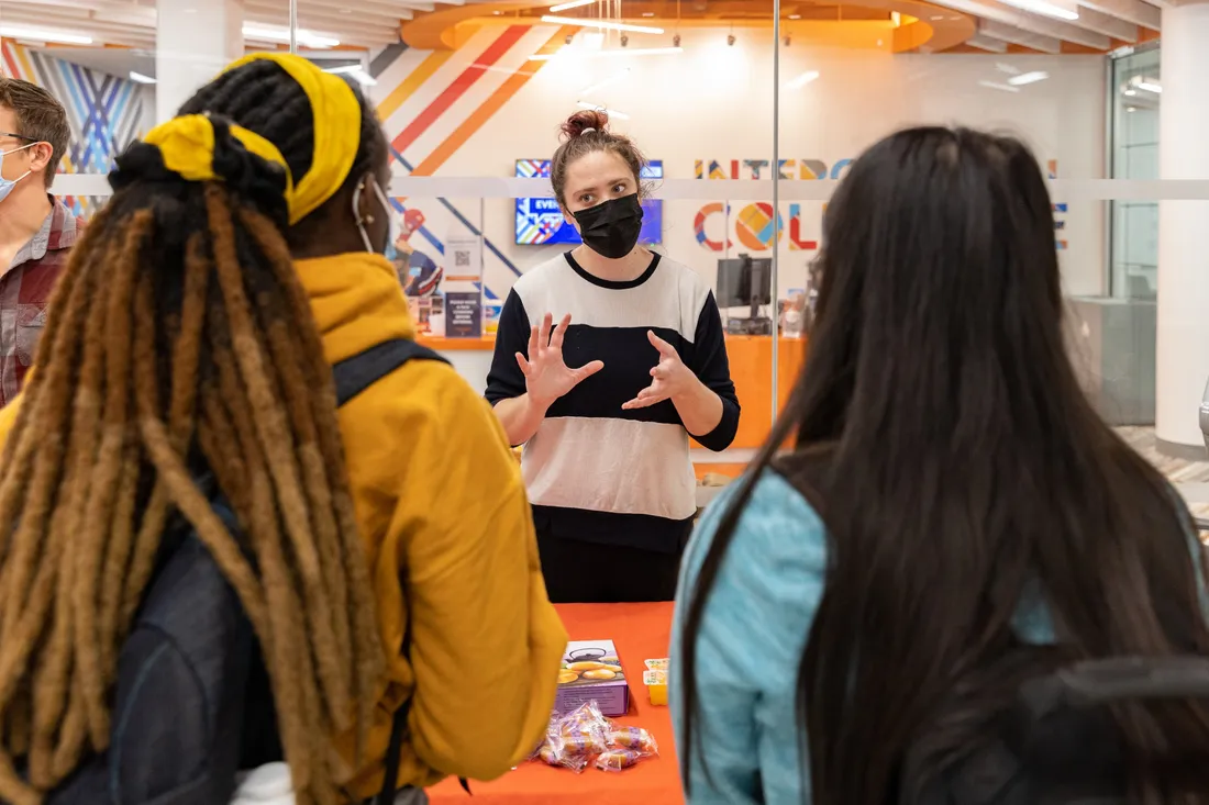 Three students at an information table outside the Intercultural Collective.