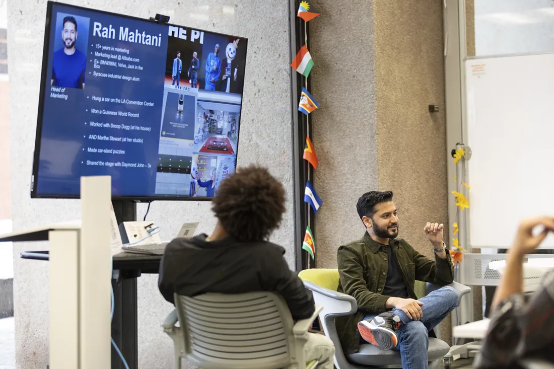 Rah Mahtani sitting in the Syracuse University Libraries' LaunchPad with current students, presenting his entrepreneurial journey.