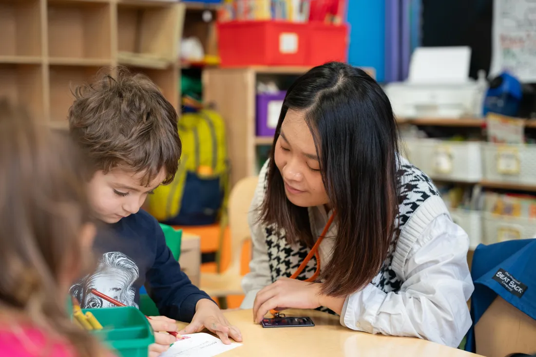 A student teacher working in a classroom with children.