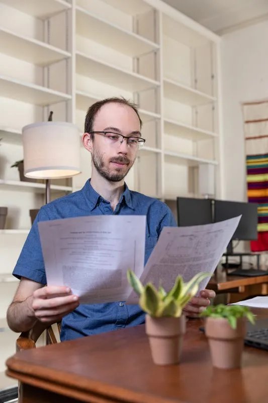 Person sitting at a desk going through documents.