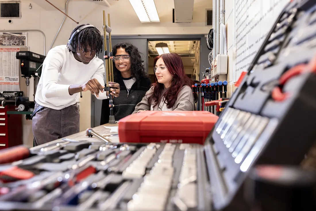 Three students work in workshop on invention.