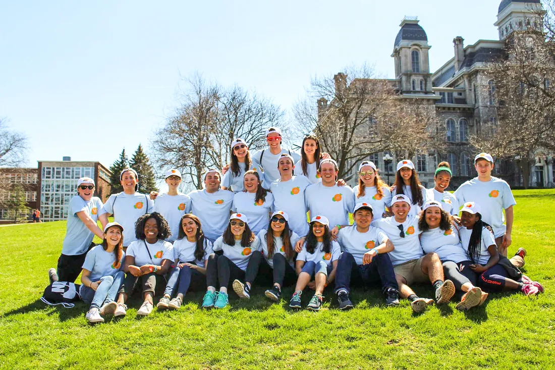 Members of OrangeSeeds posed in the grass on campus.