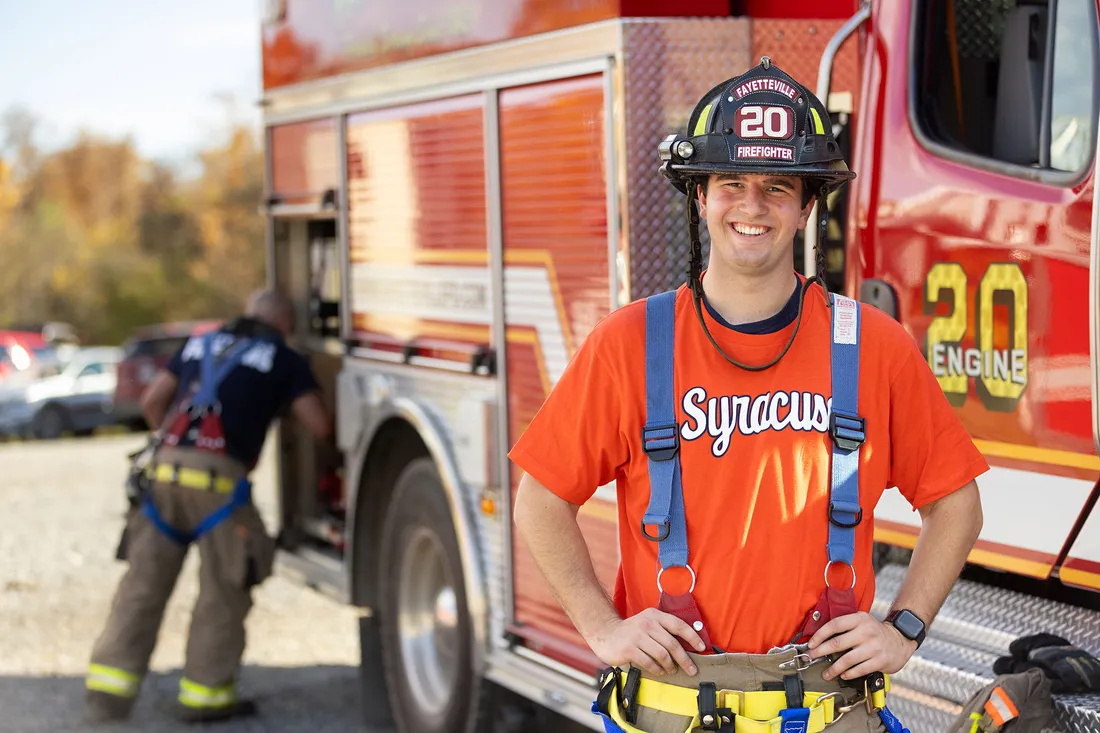 Ryan Derkowski in front of a fire truck.