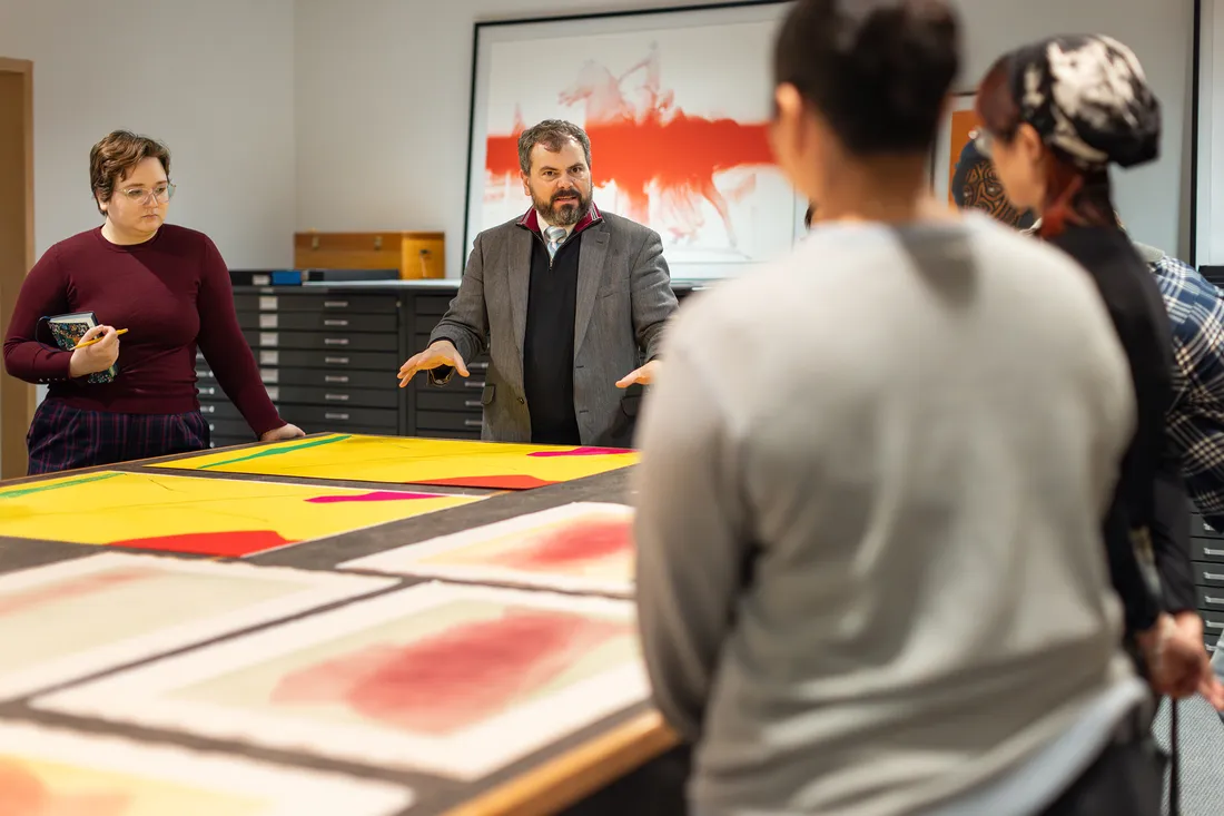 Professor talking to students in an art studio.