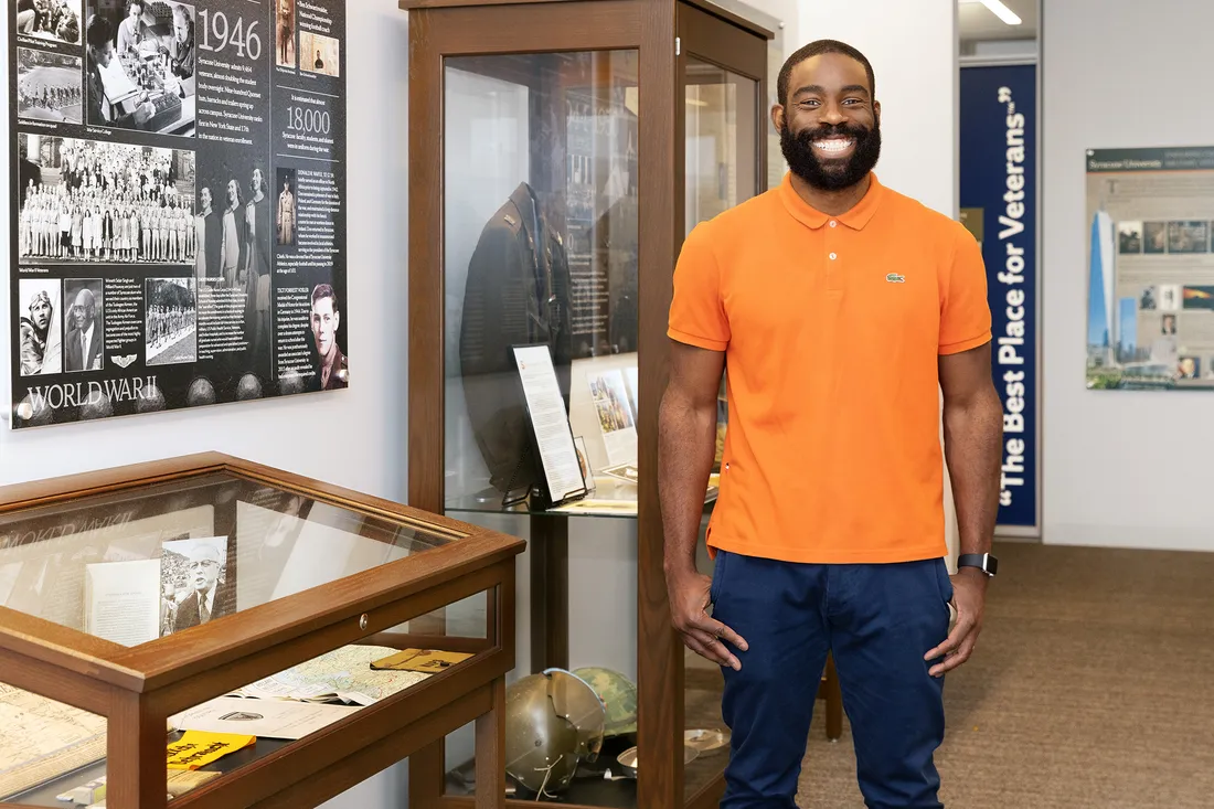 Portrait of Savion Pollard smiling in front of veteran memorabilia.