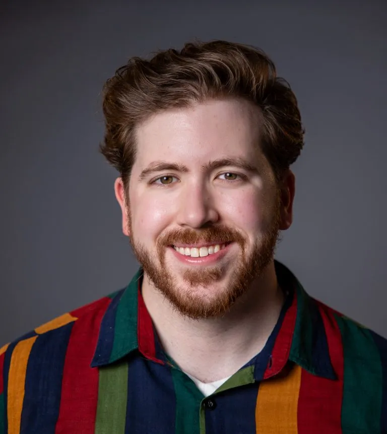 Henry Rose smiling in a striped shirt.