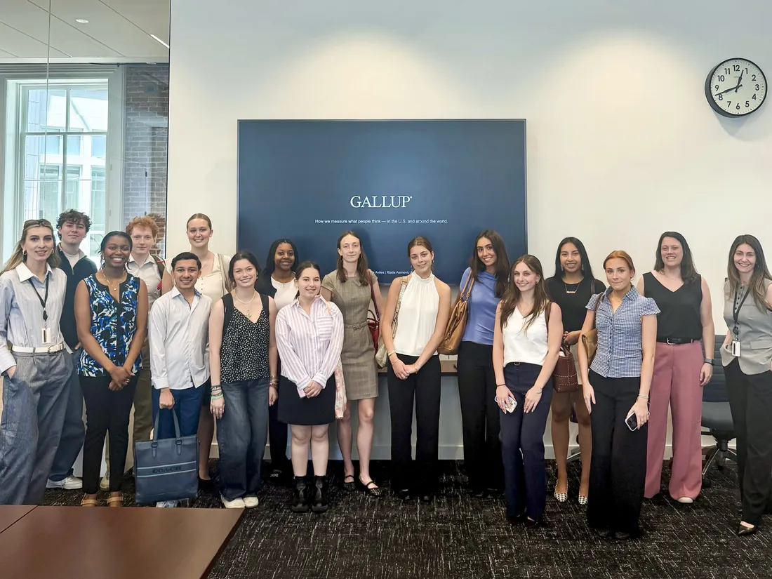 A group of students at the Gallup headquarters standing together and smiling.