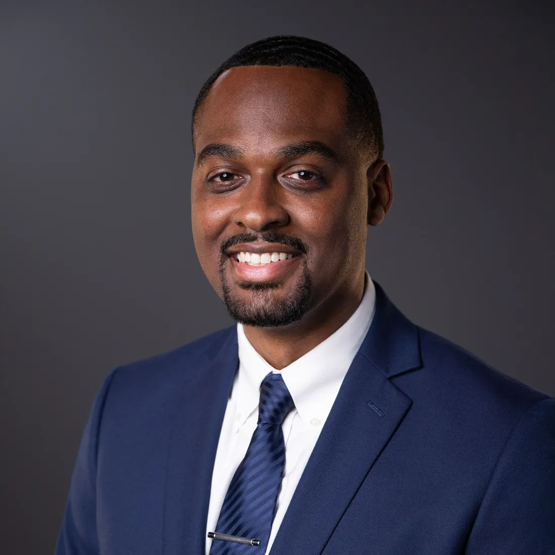 Vinny Graham smiling in a blue suit and tie.