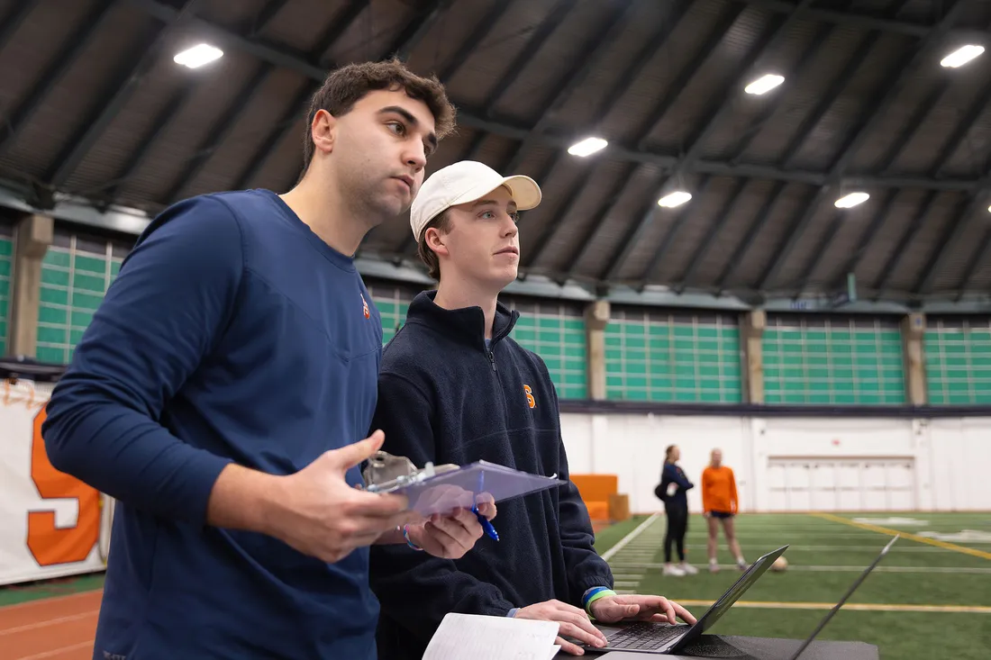 Ian Macmiller and Matthew Liddell working on the sidelines of a game.