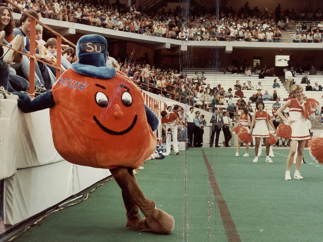 Vintage Otto the orange mascot standing inside of stadium.