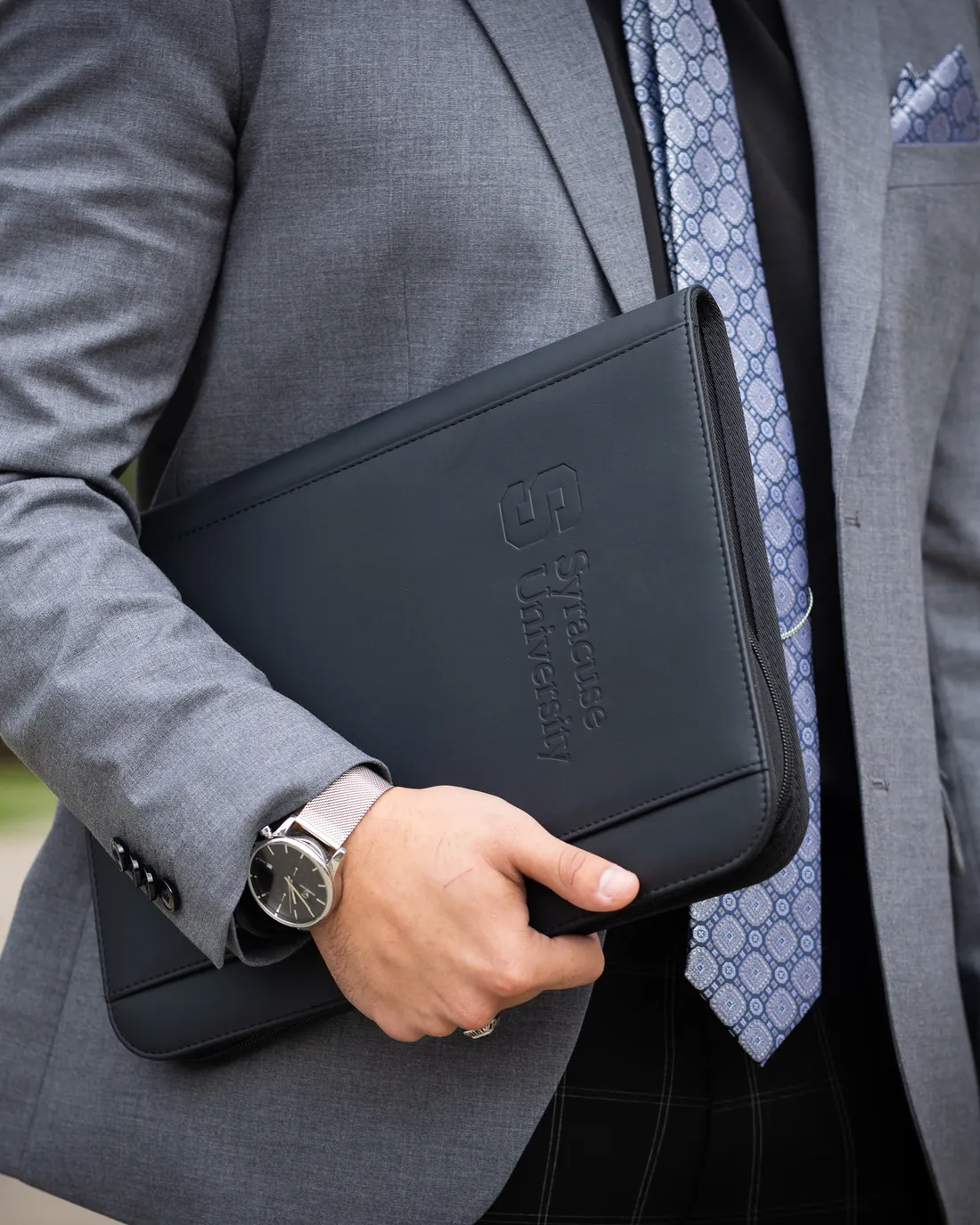 Close up of student holding a black Syracuse University binder.
