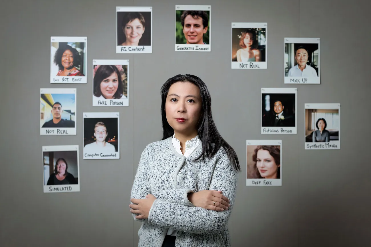 Person standing in front of images of fake people created using AI.