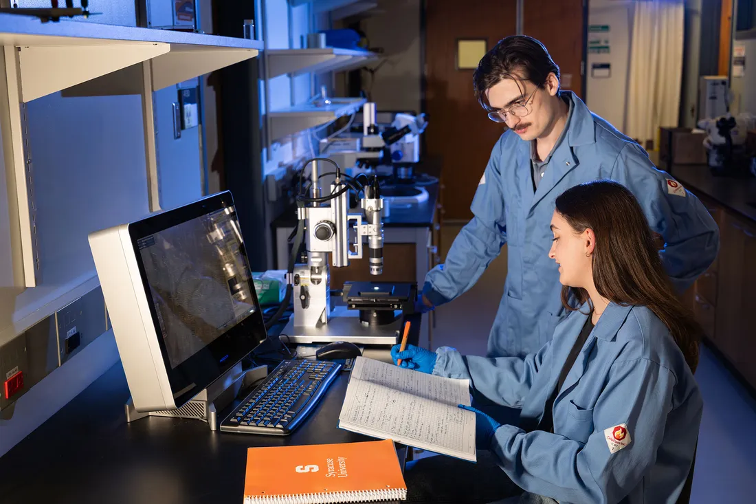 Researchers working on the computer in a lab.