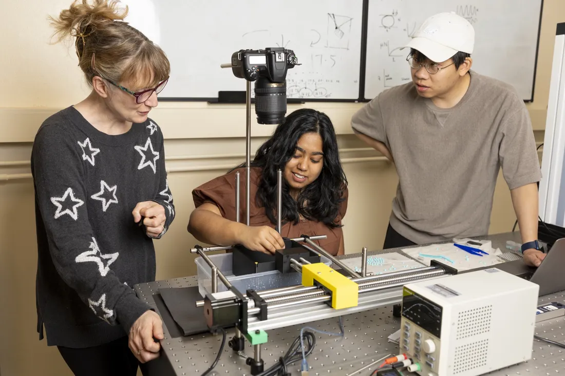 Syracuse University professor working with students in a lab.