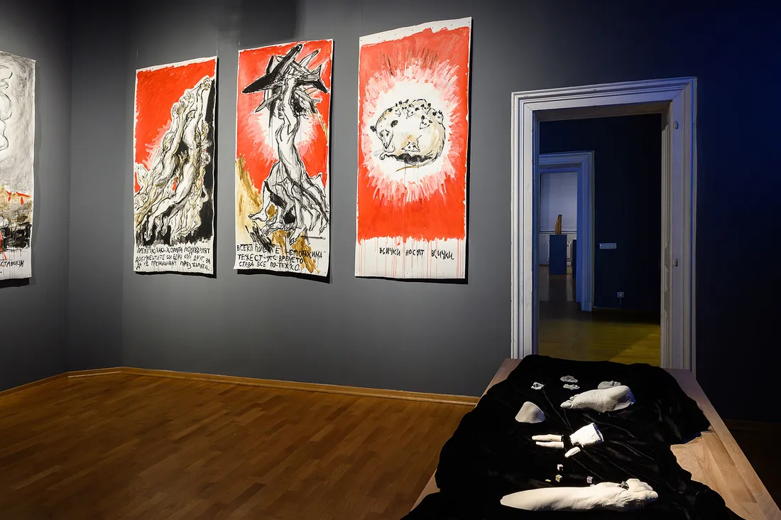 Art exhibit focusing on three multimedia panels on a gray wall.