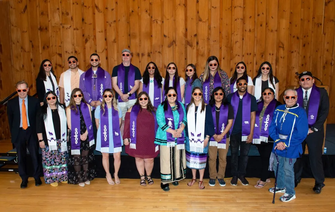 Oren Lyons and a group of graduating indigenous students pose together for a photo