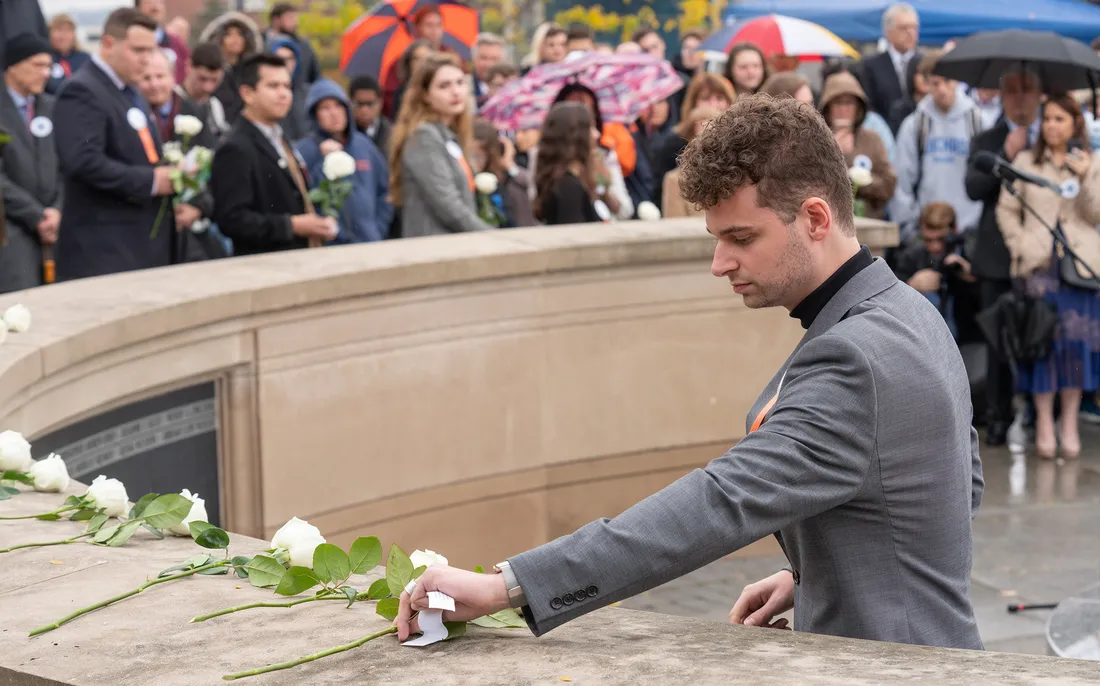 Person putting rose on wall.