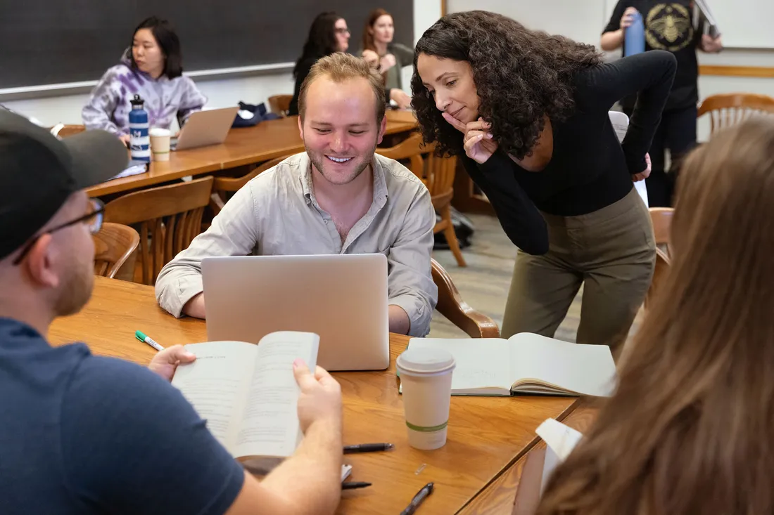 Chnelle Benz looks over student's shoulder in writing workshop.