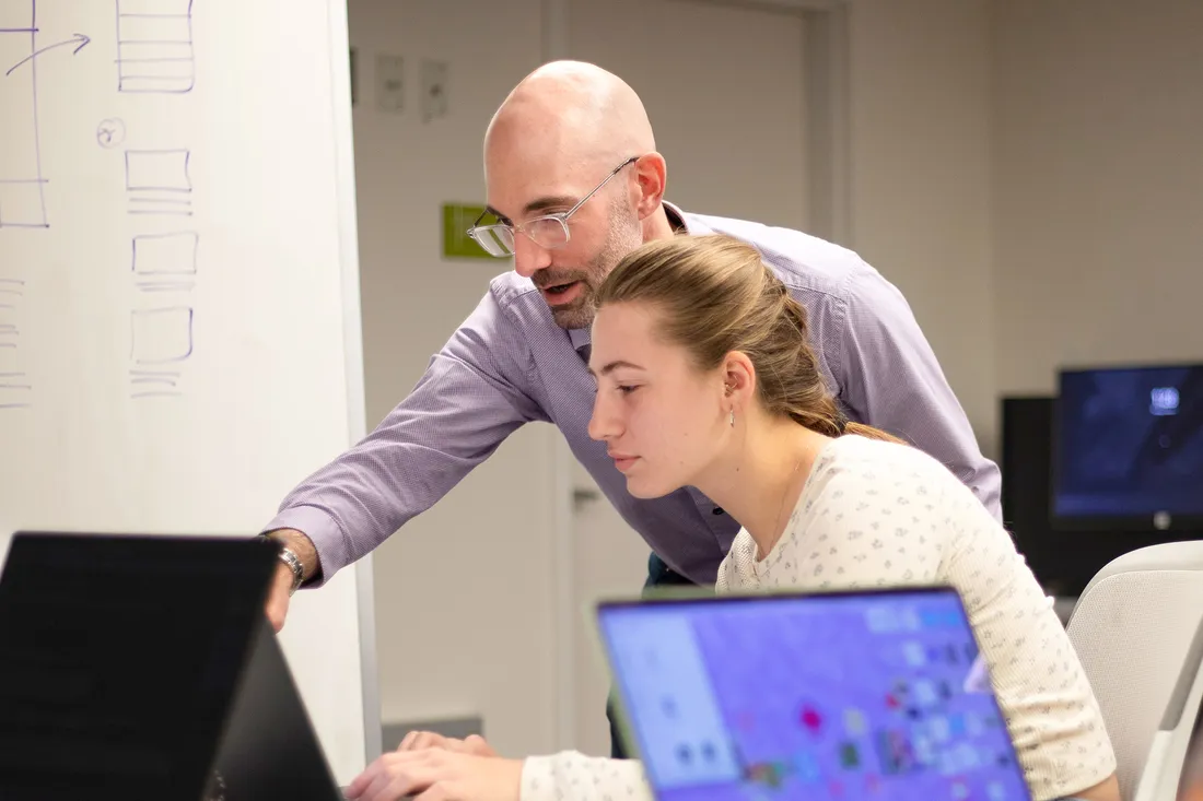 Professor and Student working on computer together.