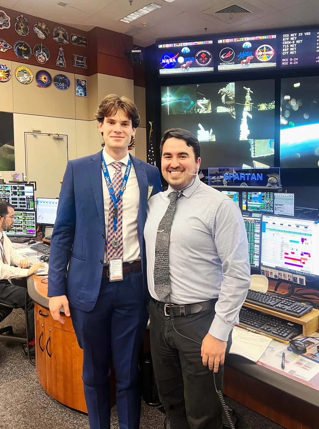 Brady McKenna with a coworker inside a control room.