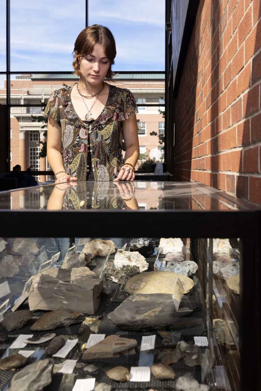 Zoe Power looking down at a display inside the Heroy Geology Building.