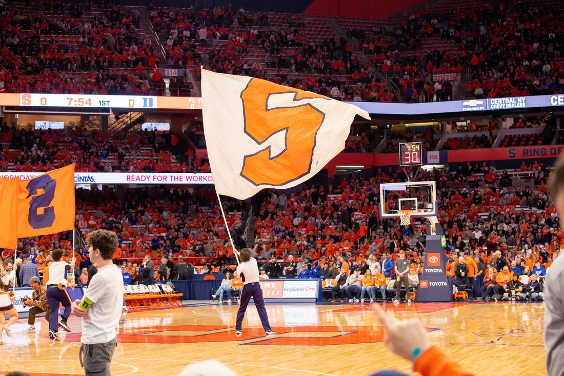 Student waiving a Syracuse University flag in the JMA Wireless Dome.