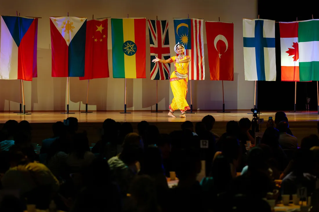 Woman dancing on stage for an audience.