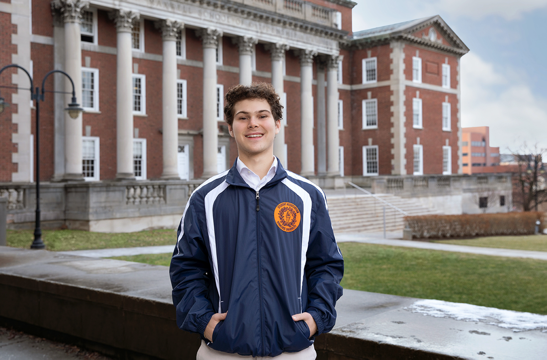 Student standing outside of the Maxwell School.