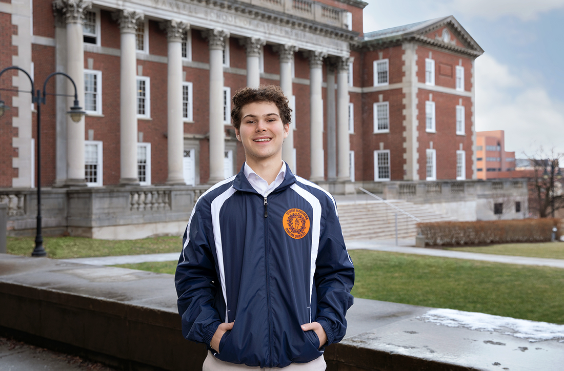 Aden Solomon standing outside of the Maxwell School.