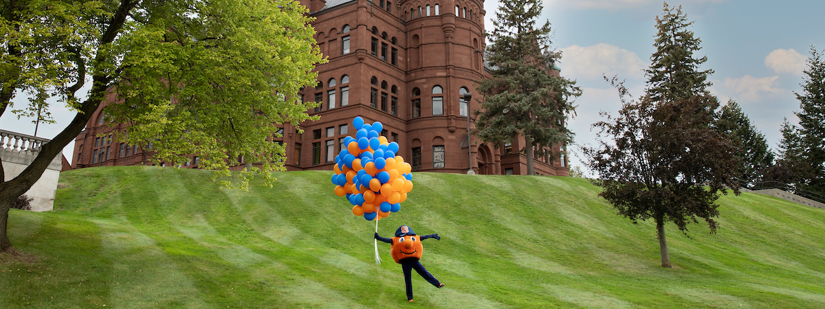 Otto in front of Crouse Hall holding balloons.